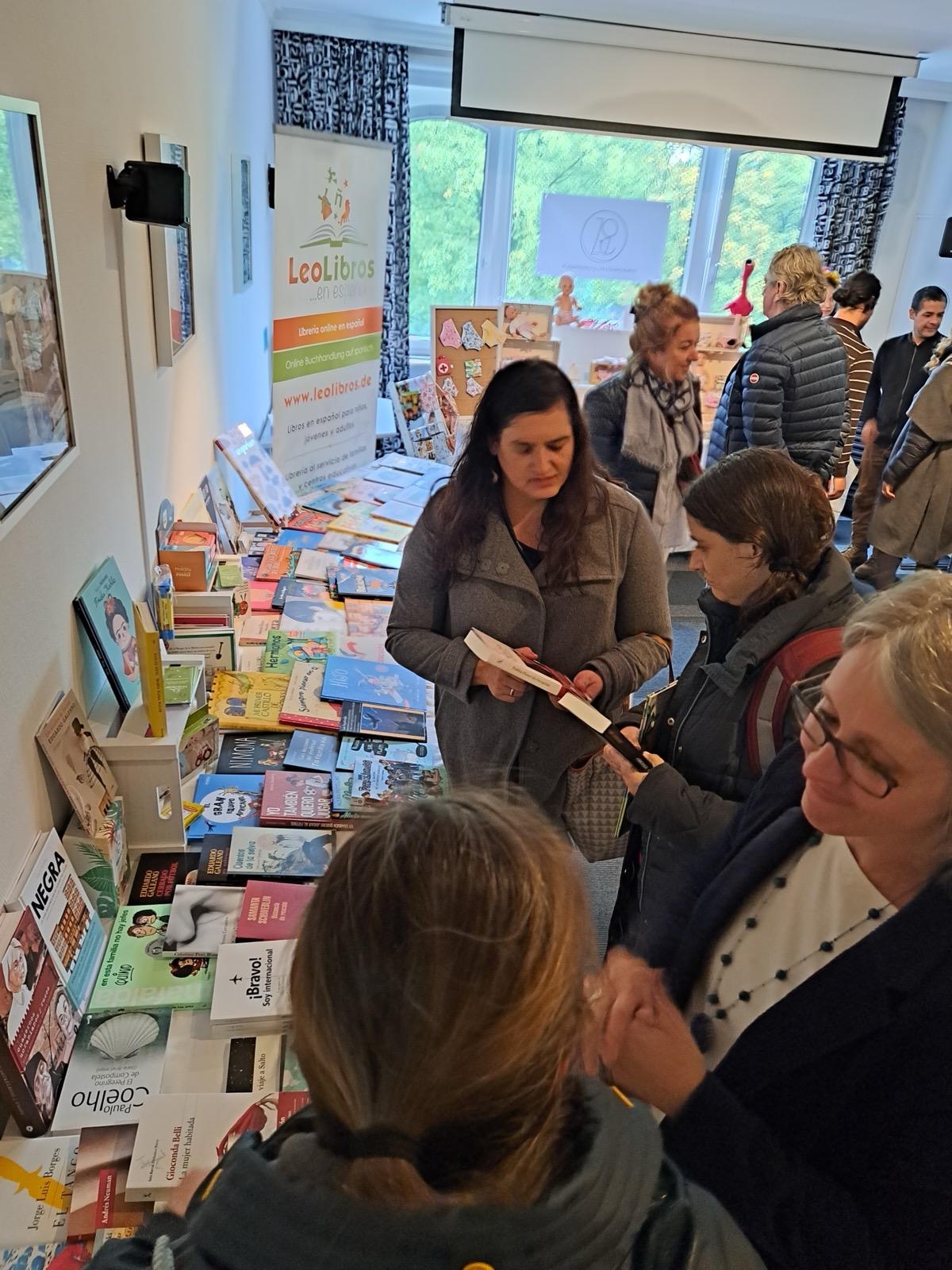 Ein Stand mit spanischsprachigen Büchern beim Lateinamerikanischen Kulturmarkt, Besucher stöbern